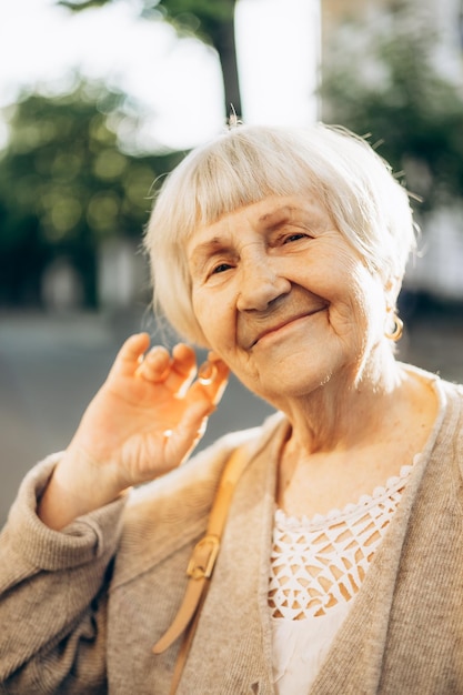 Smiling old grandmother with gray hair and a positive smile posing for a photo