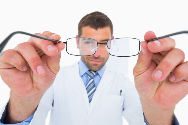 Smiling optician presenting eyeglasses