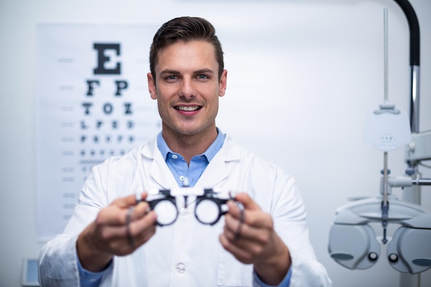 Smiling optometrist holding messbrille