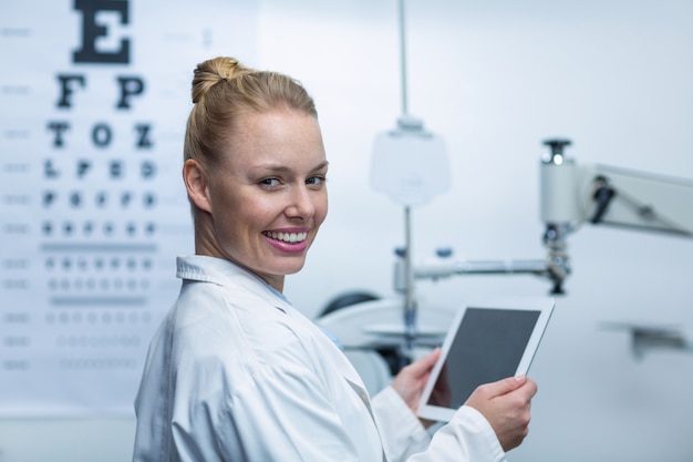 Smiling optometrist using digital tablet