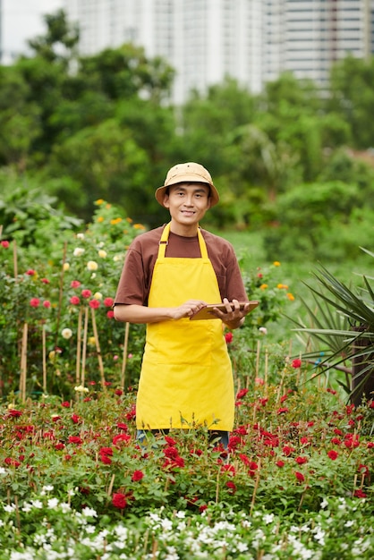 Sorridente proprietario di un negozio di fiori all'aperto