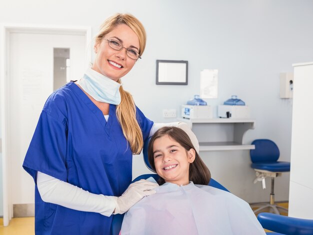 Sorridente dentista pediatrico con un giovane paziente felice