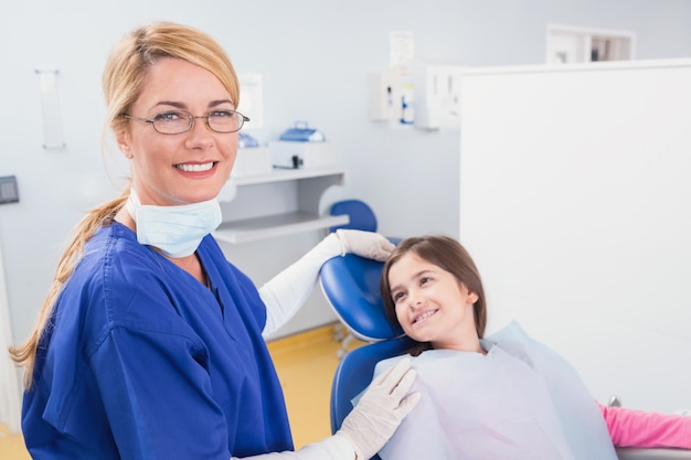 Smiling pediatric dentist with a happy young patient 