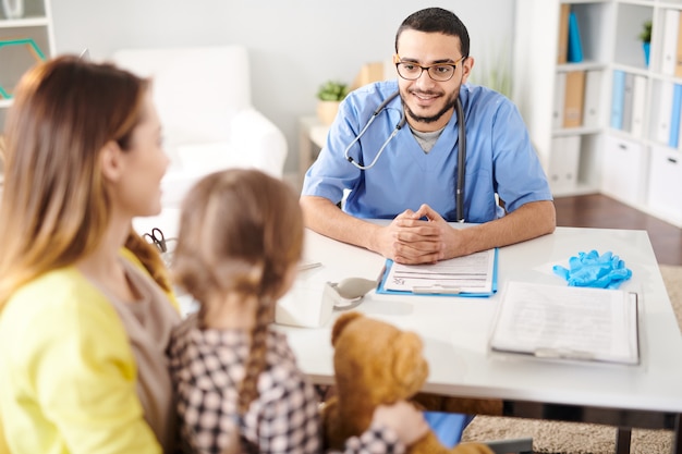 Smiling Pediatrician Talking to Little Child