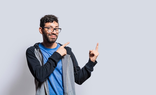 Smiling person pointing fingers to the side smiling man recommending something with fingers on isolated background isolated people pointing fingers at something