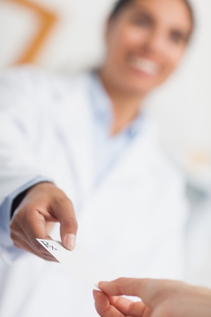 Smiling pharmacist giving Rx prescription to a customer