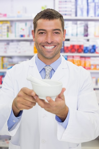 Smiling pharmacist mixing a medicine