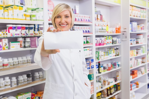 Farmacista sorridente che mostra carta alla macchina fotografica