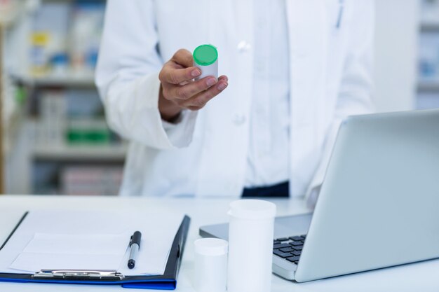 Foto farmacista sorridente che sta al contatore in farmacia