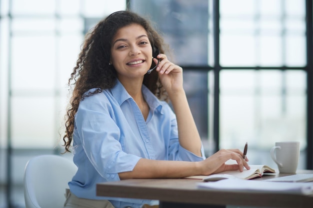 Smiling phone operator in headphones with microphone