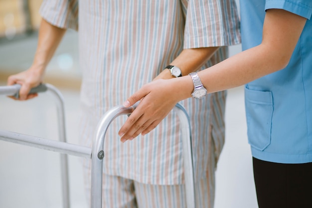 Smiling physiotherapist taking care of the happy senior patient in wheelchair