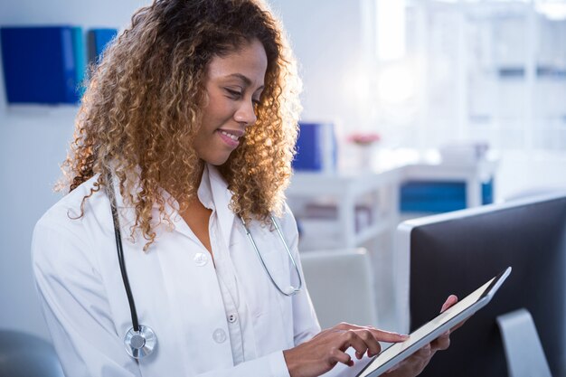 Photo smiling physiotherapist using digital tablet