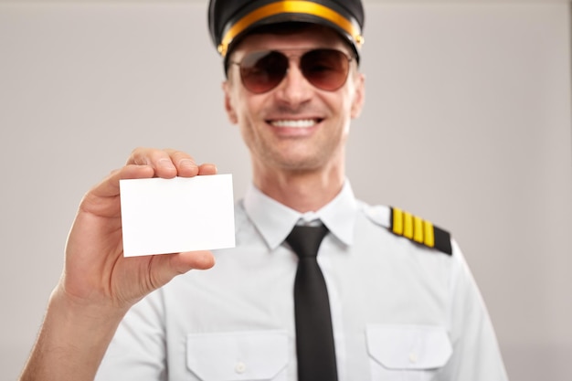 Smiling pilot showing blank business card