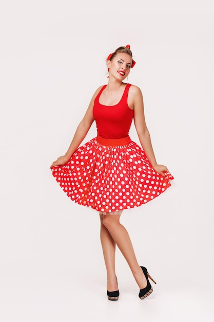 Foto sorridente pin up donna in abito rosso a pois