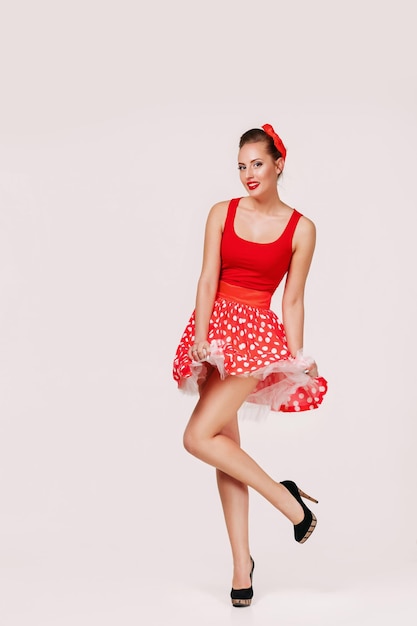 Smiling pin up woman in polka dot red dress