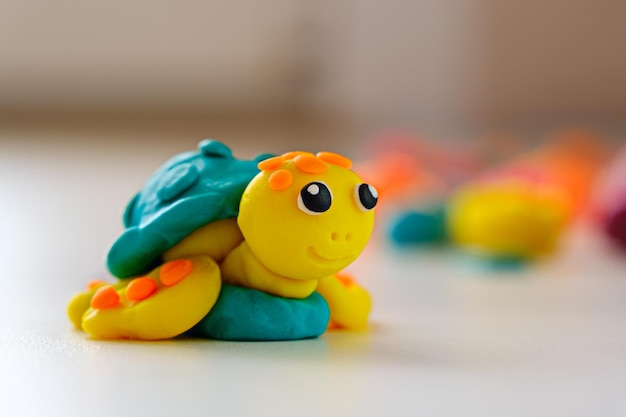 Tartaruga di plastilina sorridente su sfondo bianco artigianato per bambini fatto di concetto di creatività in primo piano di plastilina