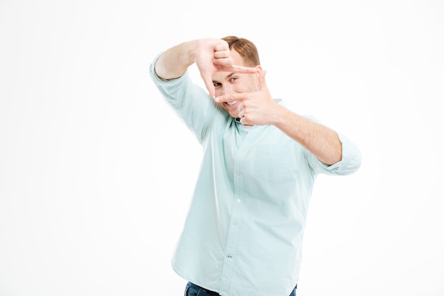 Smiling playful young man making frame by hands