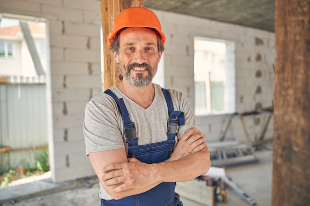 smiling pleased male worker with folded arms posing for the camera