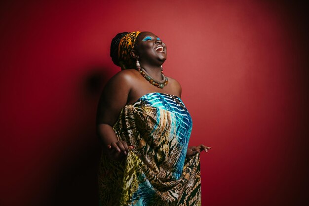 Smiling plus size african woman with beautiful makeup wearing traditional headwear