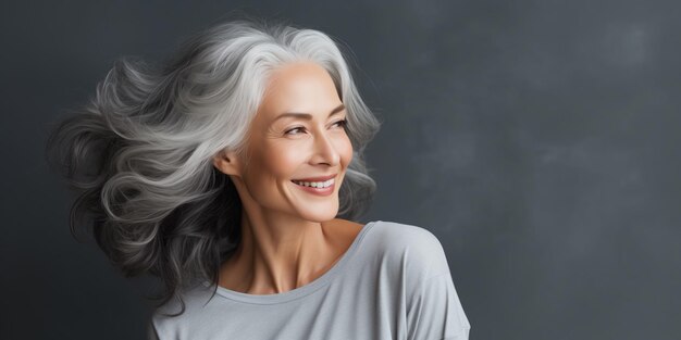 Foto ritratto sorridente di una bella donna matura con i capelli grigi e bianchi spazzati dal vento