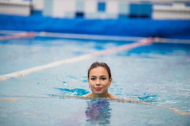 Smiling portrait of beautiful woman in swimming pool