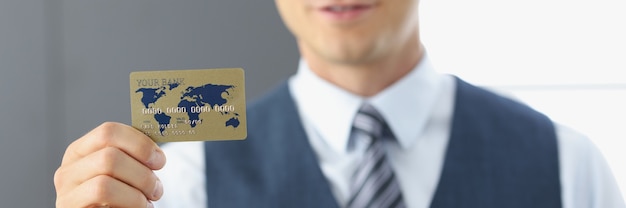 Smiling portrait of businessman holding plastic bank card in hand