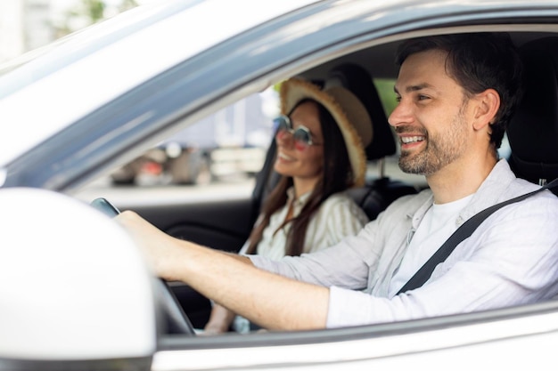 Smiling positive couple going summer vacation by car