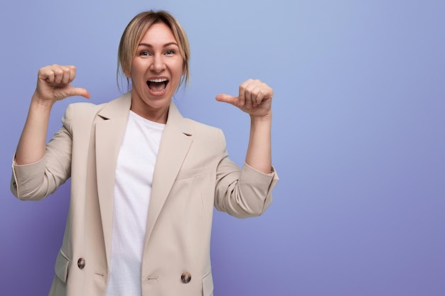 Sorridente giovane donna europea gentile positiva in una giacca su uno sfondo di studio con spazio per la copia