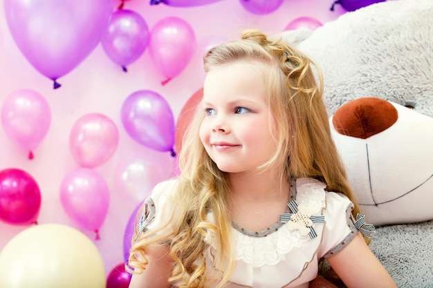 Smiling pretty blonde girl posing in playroom