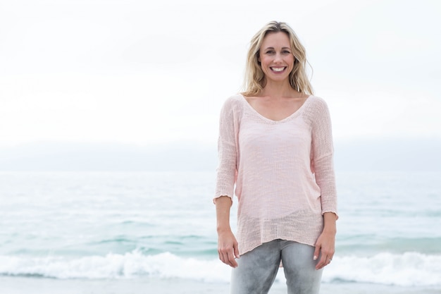 Smiling pretty blonde standing by the sea