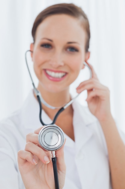 Smiling pretty nurse posing holding her stethoscope 