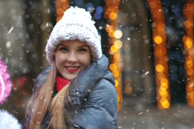 降雪時に歳の市で歩いているきれいな女性の笑顔。空きスペース