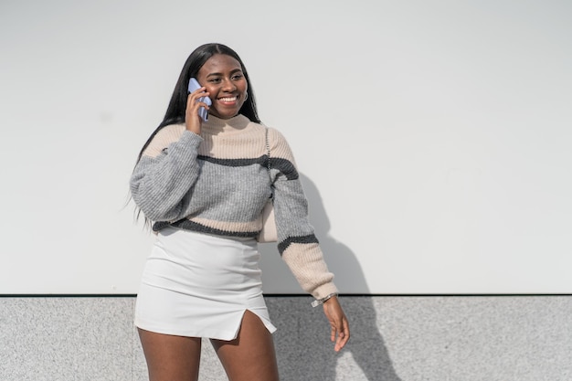 Smiling and pretty Young black woman making a phone call