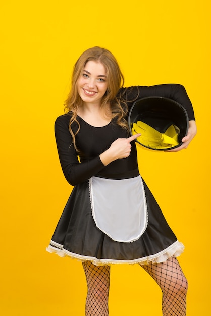 Photo smiling pretty young woman housewife in casual clothes, doing housework isolated on yellow background studio portrait. housekeeping concept. mock up copy space.