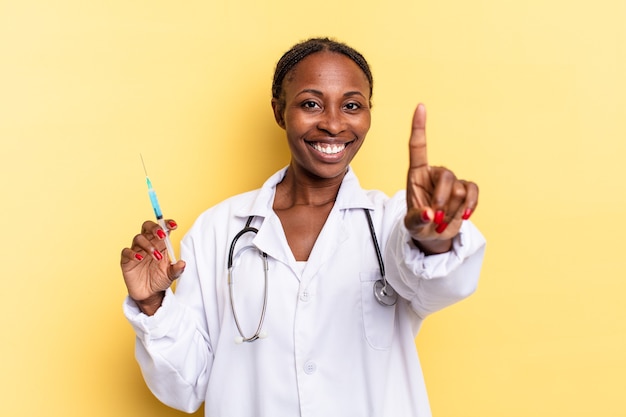 Smiling proudly and confidently making number one pose triumphantly, feeling like a leader. physician and syringe concept