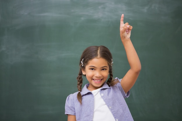 Smiling pupil raising her hand 