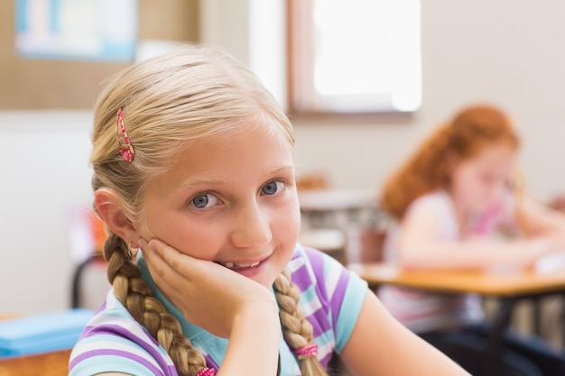 Smiling pupil sitting at her desk 