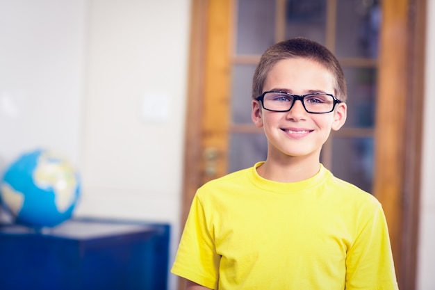 Smiling pupil wearing glasses in a classroom