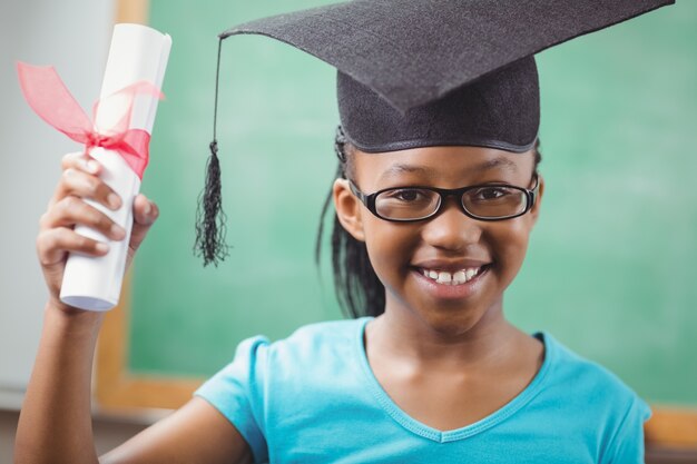 Smiling pupil with mortar board and diploma