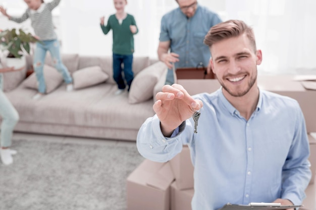 Photo smiling realtor with keys on the background of a new apartment