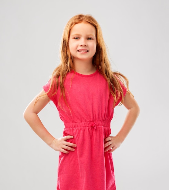 smiling red haired girl posing in pink dress