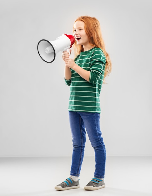 Photo smiling red haired girl speaking to megaphone