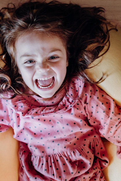 Фото Улыбающийся рыжеволосый малыш, веселящийся и кричащий дома