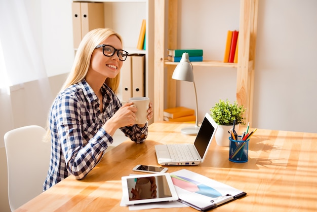 Smiling relaxed woman drinking tea and dreaming