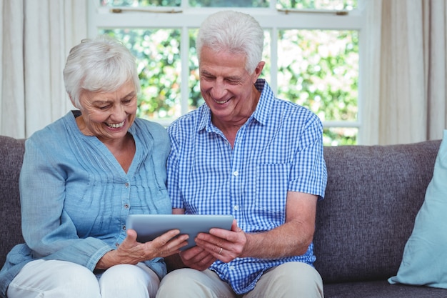 Smiling retired couple using tablet 