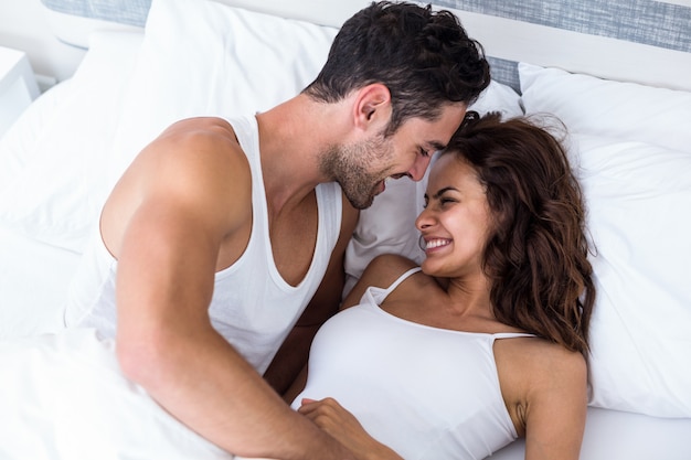 Smiling romantic couple relaxing on bed 