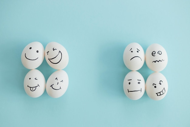 Smiling and sad eggs on a blue background