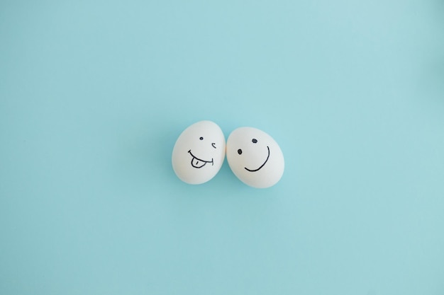 Smiling and sad eggs on a blue background