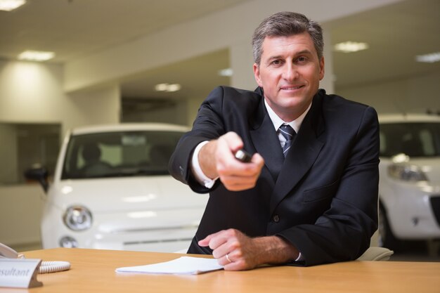 Smiling salesman giving a customer car keys