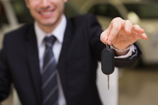 Smiling salesman giving a customer car keys